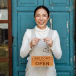 Photo by Ketut Subiyanto: https://www.pexels.com/photo/ethnic-female-cafe-owner-showing-welcome-we-are-open-inscription-4473398/